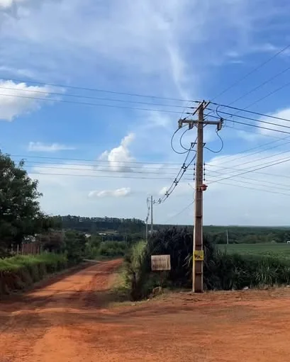 Línea de media tensión sobre un camino rural de tierra roja