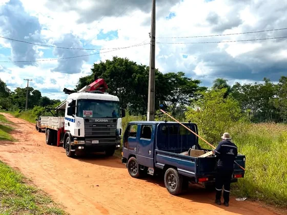 Camión grúa y camioneta de apoyo en un camino de tierra junto a la línea